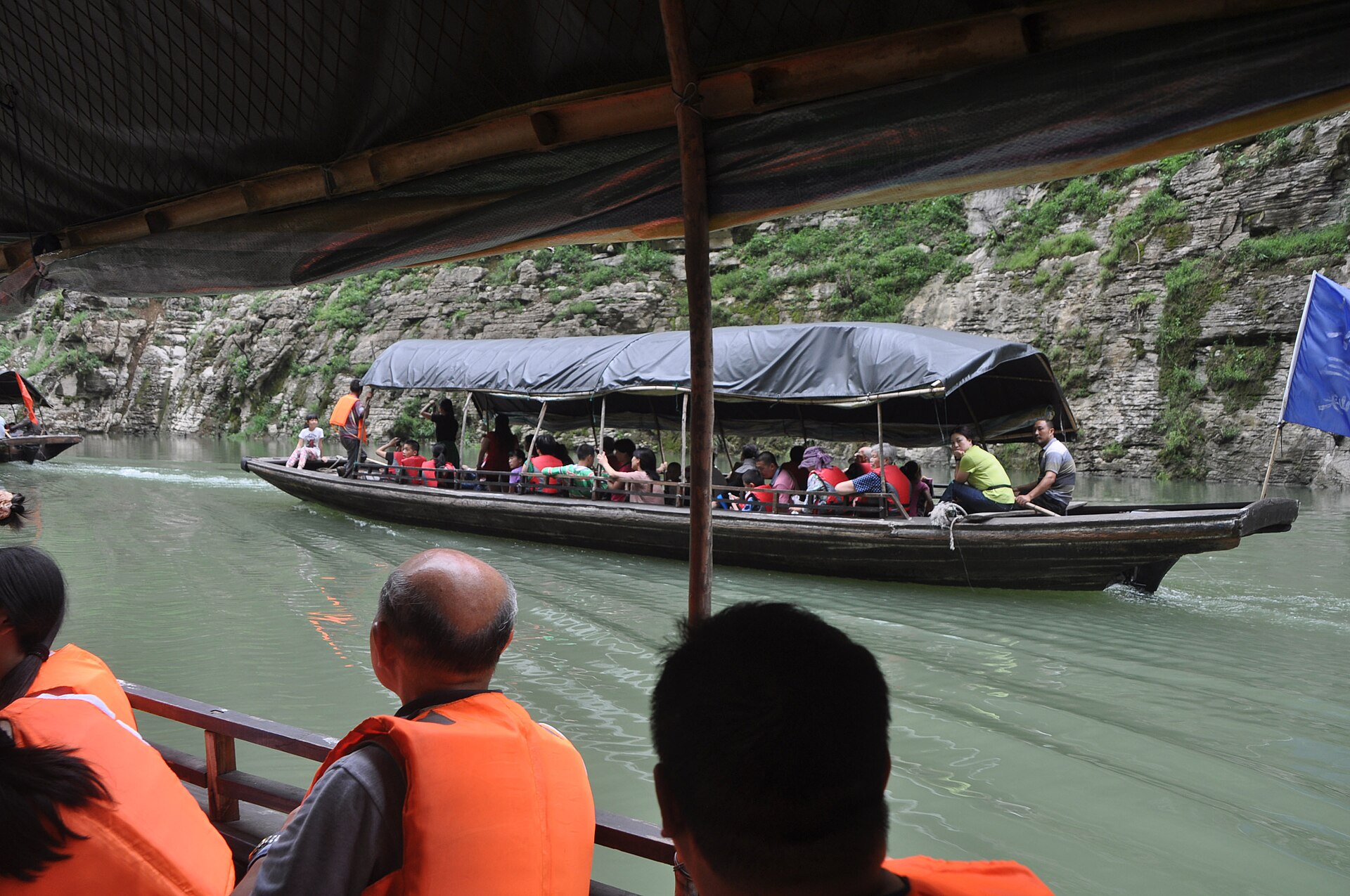 Travellers passing through the Lesser Three Gorges in small sightseeing boats